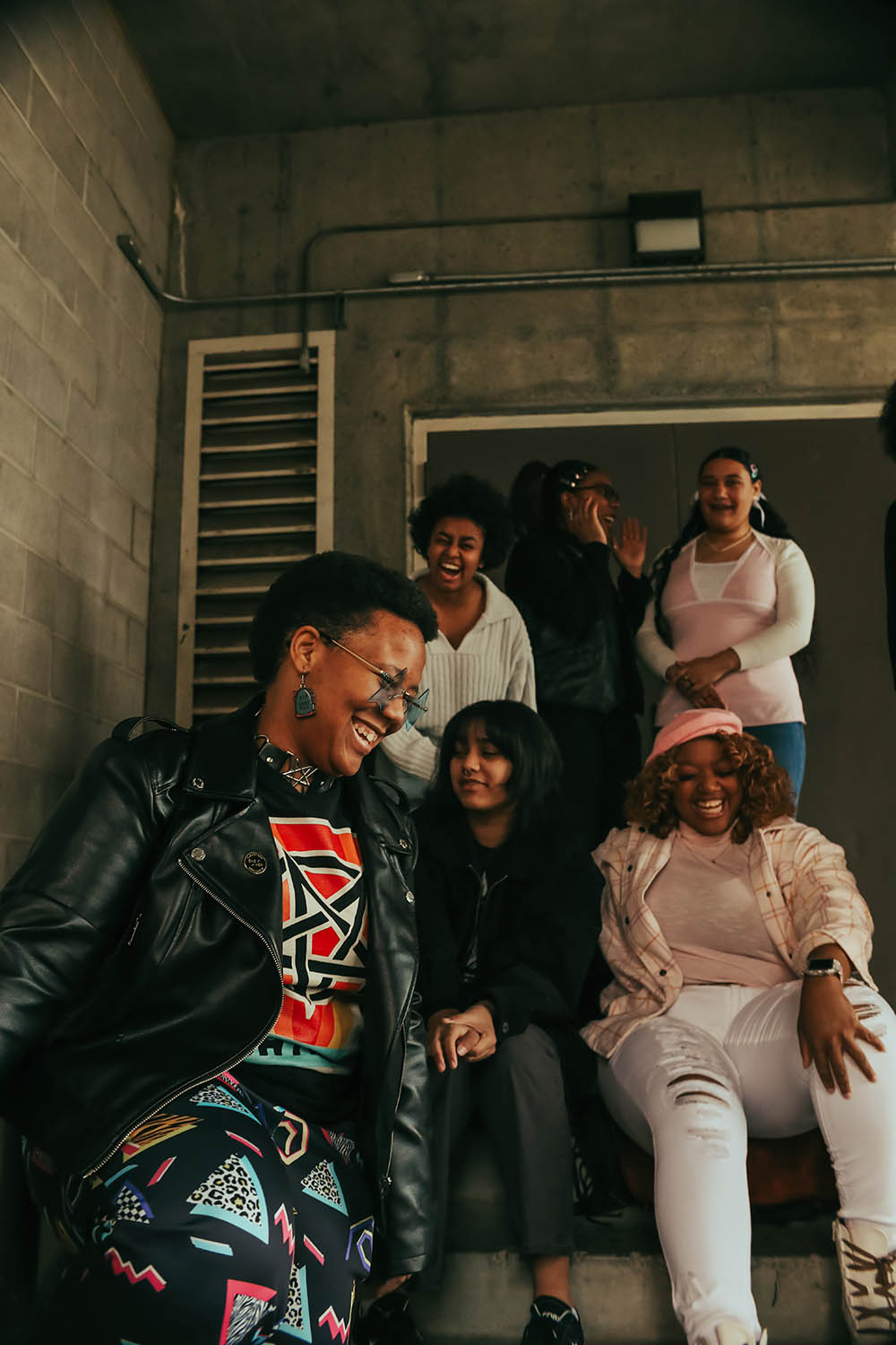 A group of Black students smiling and laughing on a stairway