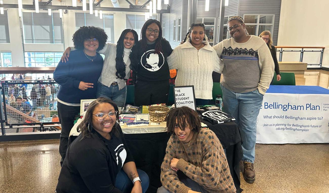 Students of the Black Student Coalition (BSC) posed together in front of a tabletop display for the BSC.